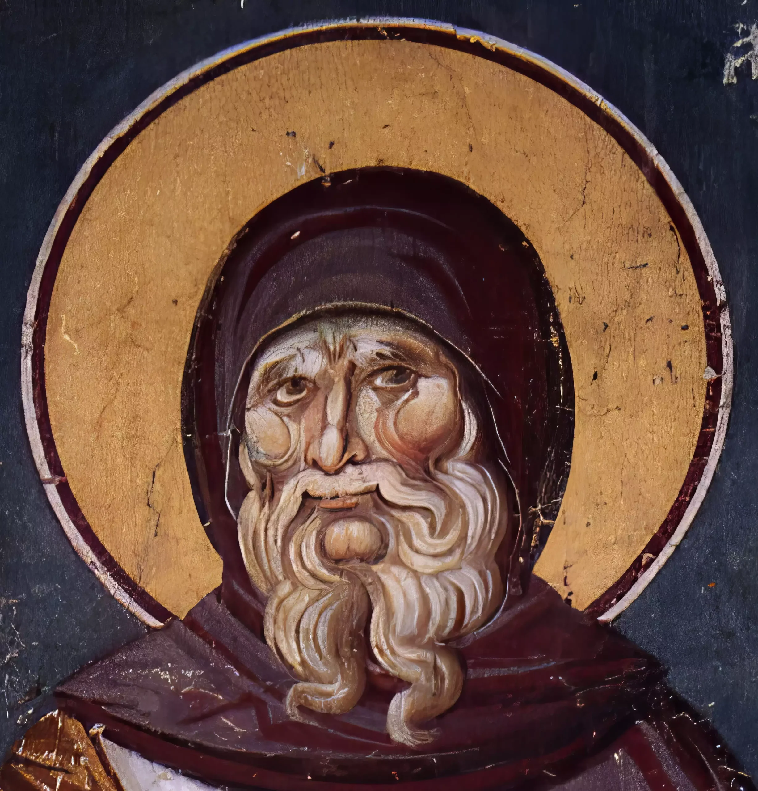 Detail view showing the face of Saint Anthony with flowing white beard, dark monastic hood, and golden nimbus, from 14th century Ohrid fresco