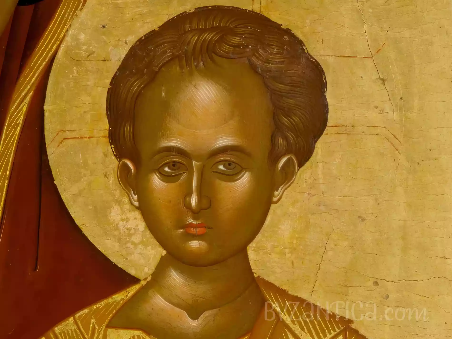 A detail of the Christ child's face from Virgin Hodegetria Byzantine icon, golden tones predominate