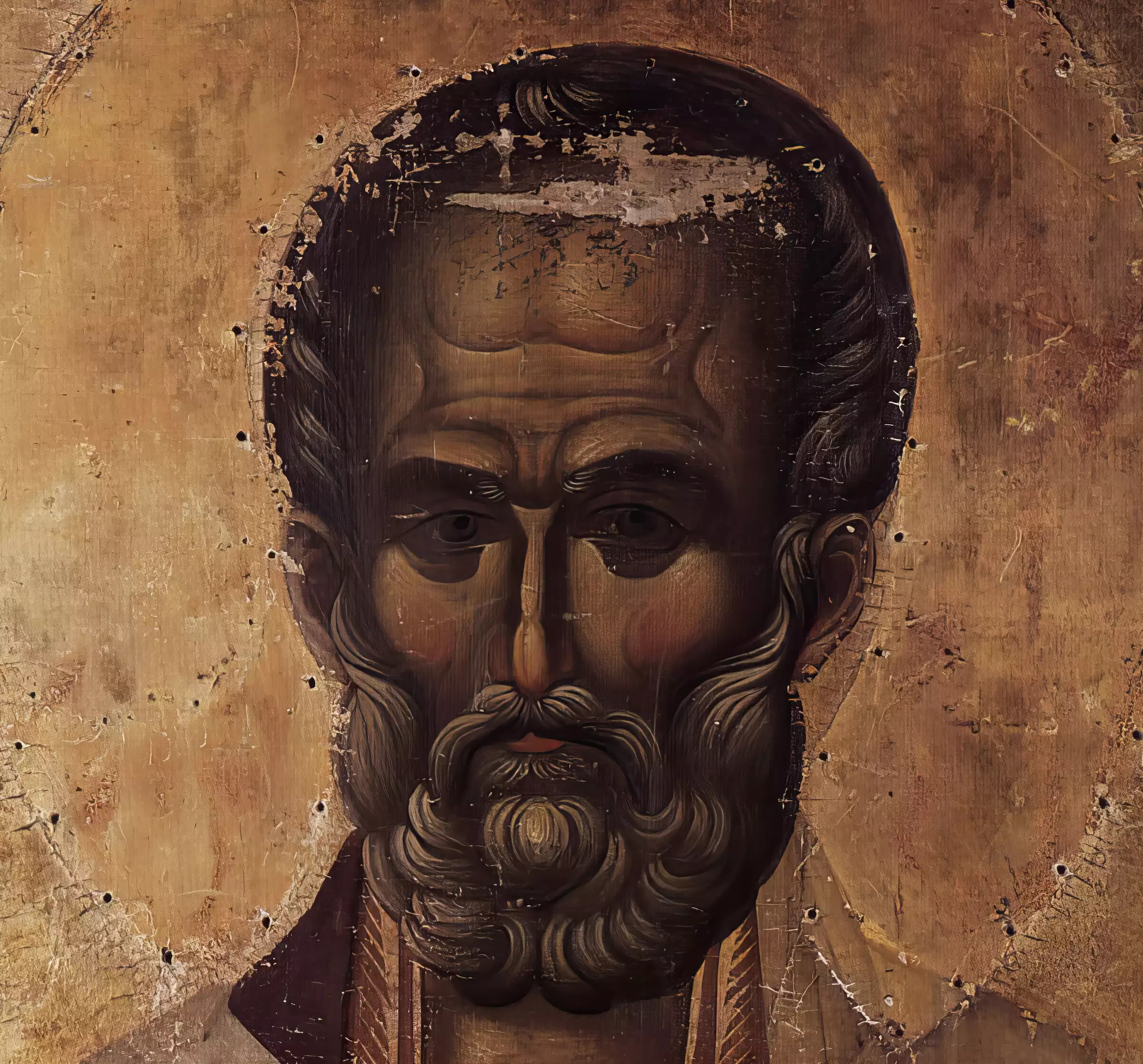 Close-up detail of Saint Nicholas's portrait from 14th century Byzantine icon showing intense gaze and beard