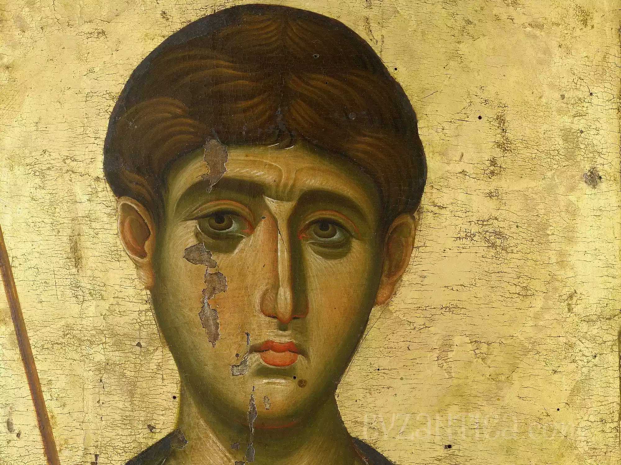 Detail of Saint Demetrios in Vatopedi icon showing youthful face with deep eyes and golden background